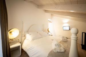 a bedroom with a white bed with towels on it at La casa del calzolaio in Altamura