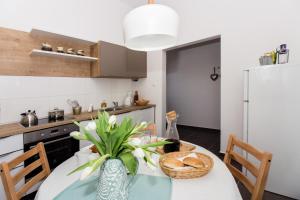 a kitchen with a table with a vase of flowers at Apartment One in Okrug Donji