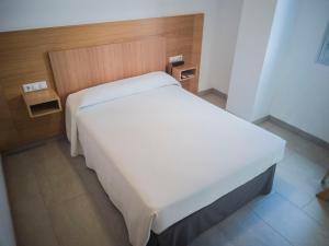 ein Schlafzimmer mit einem weißen Bett in einem Zimmer in der Unterkunft Hotel Abadi in Córdoba