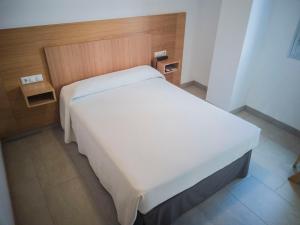 a bedroom with a white bed in a room at Hotel Abadi in Córdoba