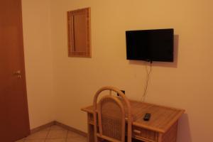 a room with a table and a television on the wall at Albergo Il Terrazzino in Vibo Valentia Marina