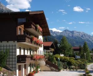 un edificio con flores en los balcones y las montañas en Salzburger Stubn en Kleinarl