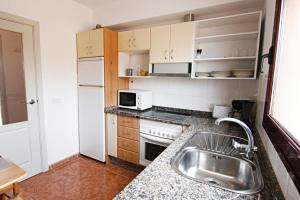 a small kitchen with a sink and a refrigerator at La Perla de Bahia Sol in Caleta De Fuste