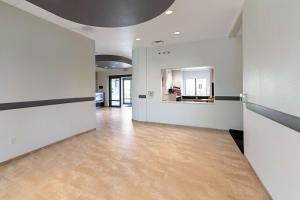 an empty room with white walls and wood floors at Motel 6 Austin Airport in Austin