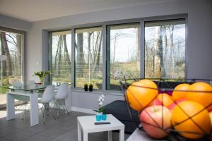 sala de estar con ventanas, mesa y sillas en Villa Klif, en Rewal