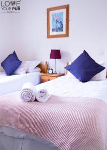 two beds with towels on top of them in a bedroom at The Rising Sun Inn in Waterlooville