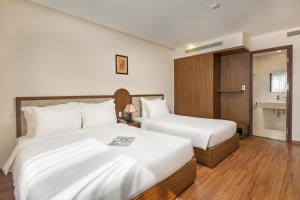 Postel nebo postele na pokoji v ubytování De Lamour Hotel Da Nang
