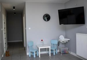 sala de estar con sillas y TV en la pared en Villa Klif, en Rewal
