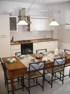 a kitchen with a wooden table with four chairs at Solo Per Quattro in Zocca