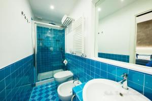 a blue tiled bathroom with a toilet and a sink at Sea House Porto Ercole in Porto Ercole +44 photos