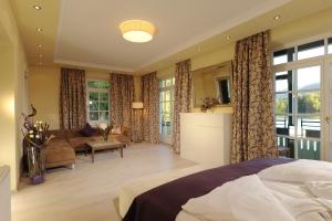 a bedroom with a bed and a living room at Hotel & Gasthof Fürberg in Sankt Gilgen