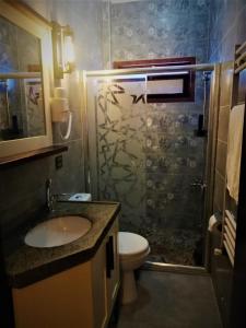 uma casa de banho com um chuveiro, um lavatório e um WC. em Kayıbeyi Hotel & Restaurant em Bursa