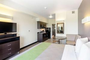 um quarto de hotel com uma cama e uma televisão de ecrã plano em Studio 6 Austin Airport em Austin