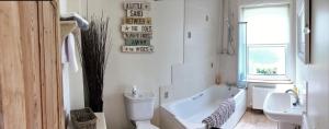 a bathroom with a tub and a toilet and a sink at Beautiful Character Property in Angmering