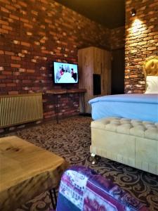 a living room with a bed and a tv at Kayıbeyi Hotel & Restaurant in Bursa