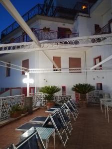 a patio with chairs and tables and a building at Hotel Dania in Sorrento