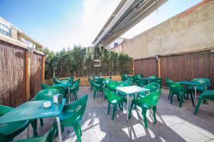 - une rangée de tables et de chaises vertes sur la terrasse dans l'établissement LA POSADA DE HIGUERUELA, à Higueruela