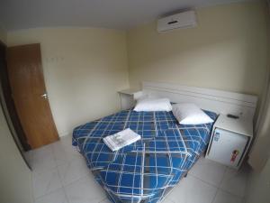 um pequeno quarto com uma cama com duas toalhas em Hotel Blumenpark em Rio Negro