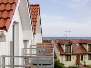 a balcony with a view of some buildings at Palisander z widokiem na morze in Trzęsacz