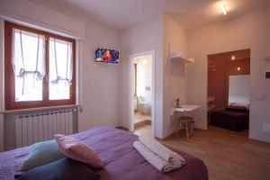 a bedroom with a large bed and a bathroom at La Camelia Bianca B&B in Lerici