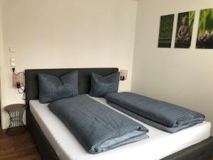 a bed with two blue pillows on top of it at Sweet Park Appartements in Rheinhausen