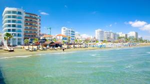uma praia com edifícios e o oceano e o oceano em Dezo Luxury town Apartment em Lárnaca