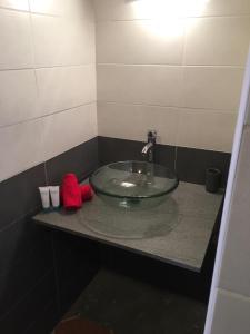 lavabo en el baño con una encimera de cristal en 13 residence belle de nuit, en Bouillante