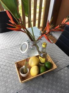 a tray of fruit on a table with a vase at 13 residence belle de nuit in Bouillante