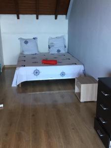 1 dormitorio con 1 cama con sábanas blancas y suelo de madera en 13 residence belle de nuit, en Bouillante