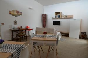 uma sala de estar com uma mesa e uma televisão em B&B Lara Santola em Corato
