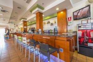 a restaurant with a bar with chairs and a tv at LA POSADA DE HIGUERUELA in Higueruela