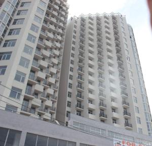 Un edificio alto y blanco con balcones. en Here comes the sun, en Batumi