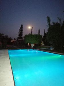 een blauw zwembad 's nachts met een straatlicht bij Hotel Quinta Moctezuma in Oaxtepec