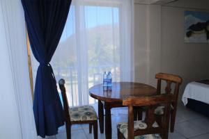 um quarto com uma mesa e cadeiras e uma janela em Hotel Mayto em Ipala