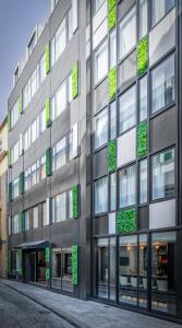 a tall building with windows and green plants on it at Hotel Moon & Sun Porto in Porto