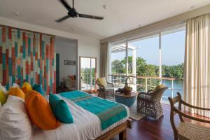 een slaapkamer met een bed en een balkon bij 33 Lake Terrace in Hikkaduwa