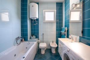 a bathroom with a tub and a toilet and a sink at Horizont view apartment in Pula