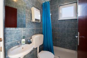 a bathroom with a sink and a toilet and a window at Horizont view apartment in Pula