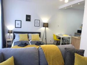 a bedroom with a bed with a yellow blanket on it at Apartament Szczęśliwa 13 - Plac Ratuszowy in Jelenia Góra