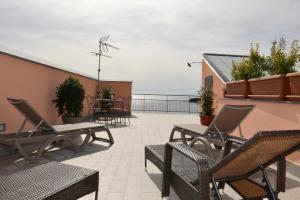 a patio with chairs and tables on a roof at Niria Home in Catania