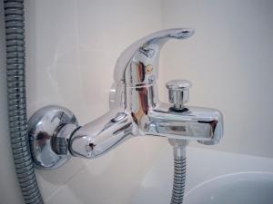 a chrome shower faucet in a bathroom at Hotel Abadi in Córdoba