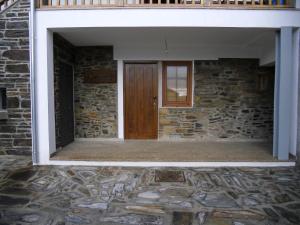 een toegang tot een stenen gebouw met een houten deur bij Casas de Campo Podence in Macedo de Cavaleiros