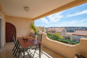 a patio with a table and chairs on a balcony at Horizont view apartment in Pula