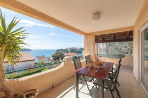 a patio with a table and chairs on a balcony at Horizont view apartment in Pula