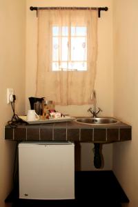 eine Küchentheke mit einem Waschbecken und einem Fenster in der Unterkunft Hadassa Guest House in Otjiwarongo