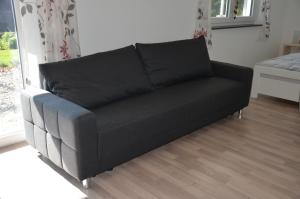 a black couch sitting in a living room at Ferienwohnung Bühlingen in Rottweil