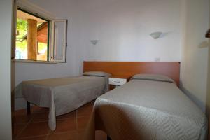 a room with two beds and a window at Baia di Zambrone in Zambrone