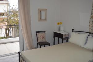 een slaapkamer met een bed en een bureau en een balkon bij The Beach House in Nydri