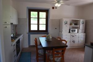 a kitchen with a table and chairs and a table and a table at Villa con piscina e intera struttura a uso esclusivo casa del moré in La Morra
