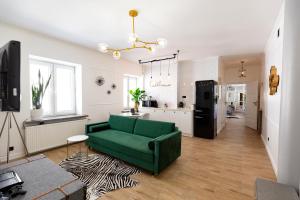 sala de estar con sofá verde y cocina en Amazing Apartment in the Heart of City Center, en Lublin